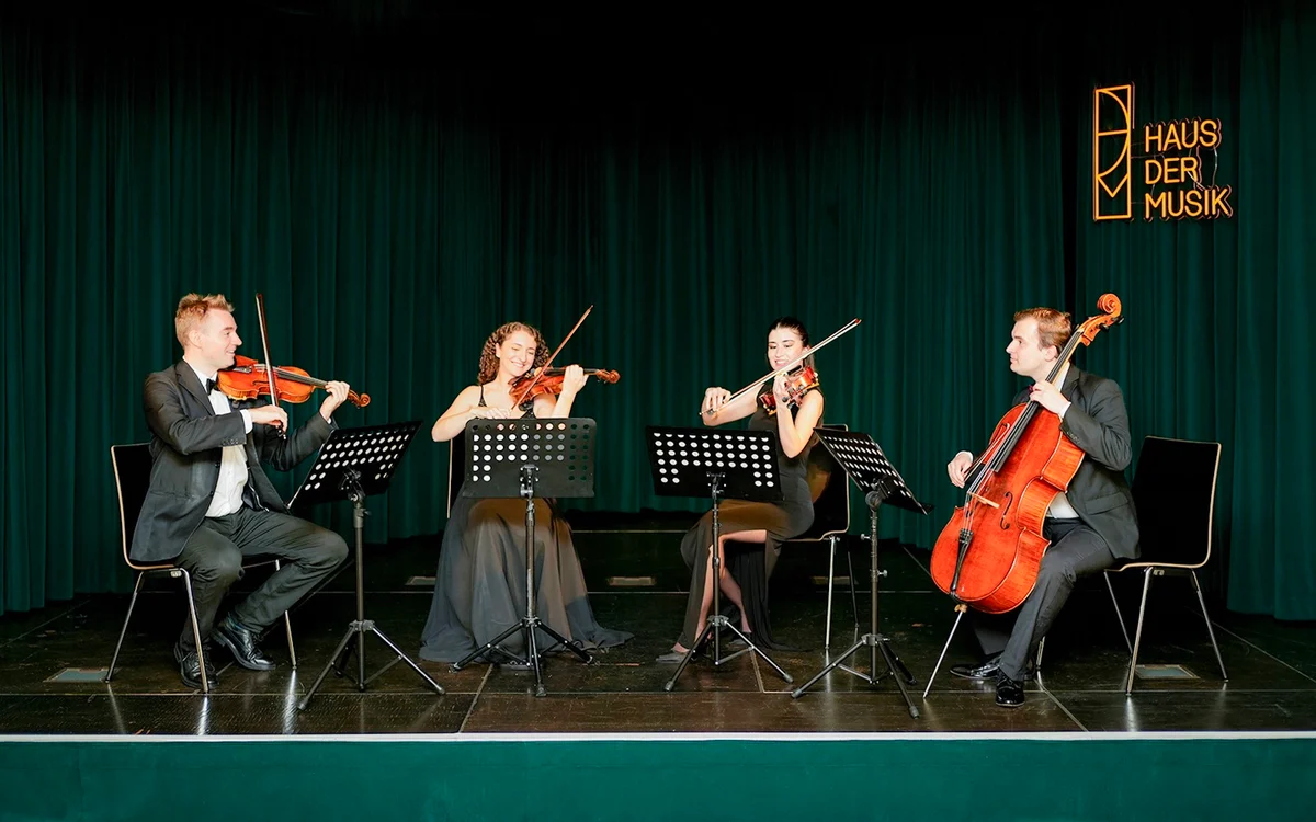 Four string musicians performing on stage at Haus der Musik