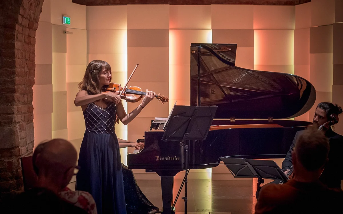 Violinist beside a grand piano during a Mozarthaus concert