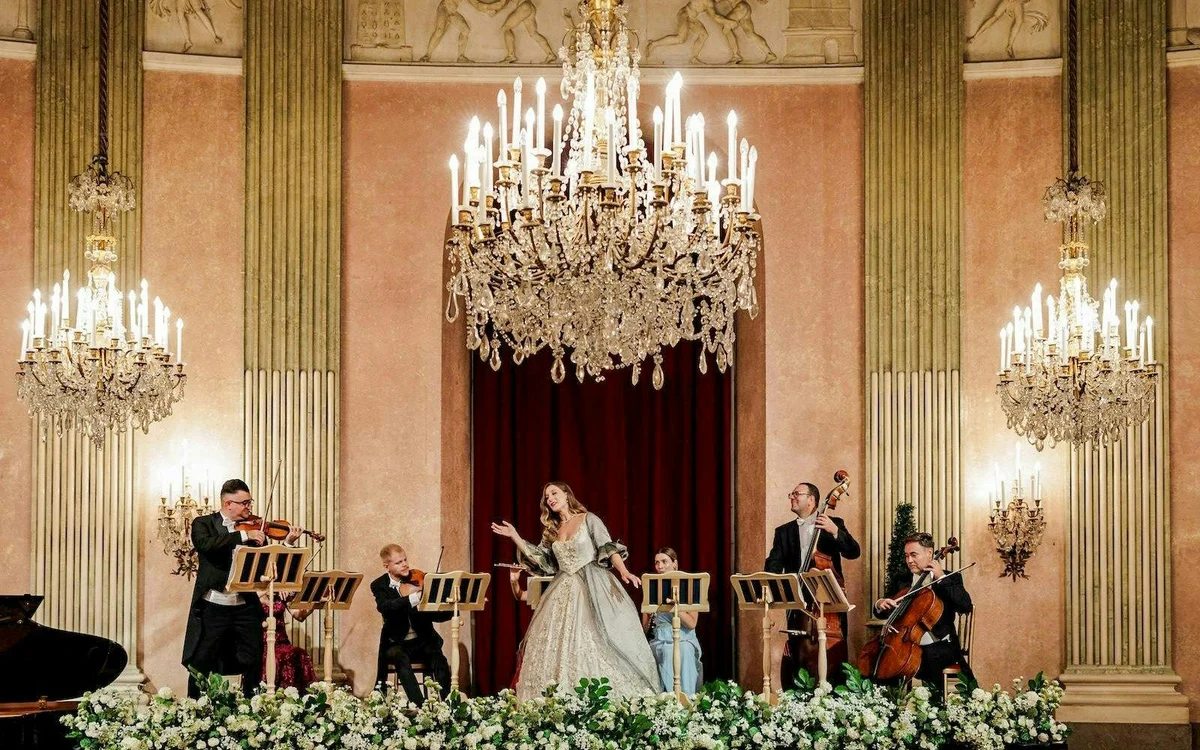 Singer and orchestra performing beneath chandeliers at Palais Auersperg