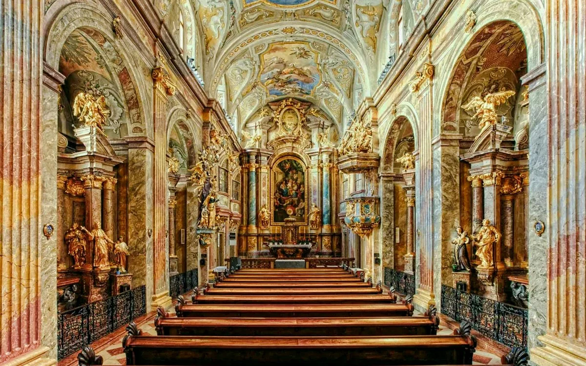 Rows of wooden pews leading towards the gilded altar in St Anne’s Church