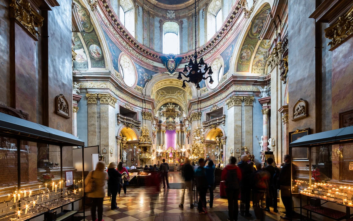 Visitors beneath the painted dome and gilded altar of St Peter’s Church